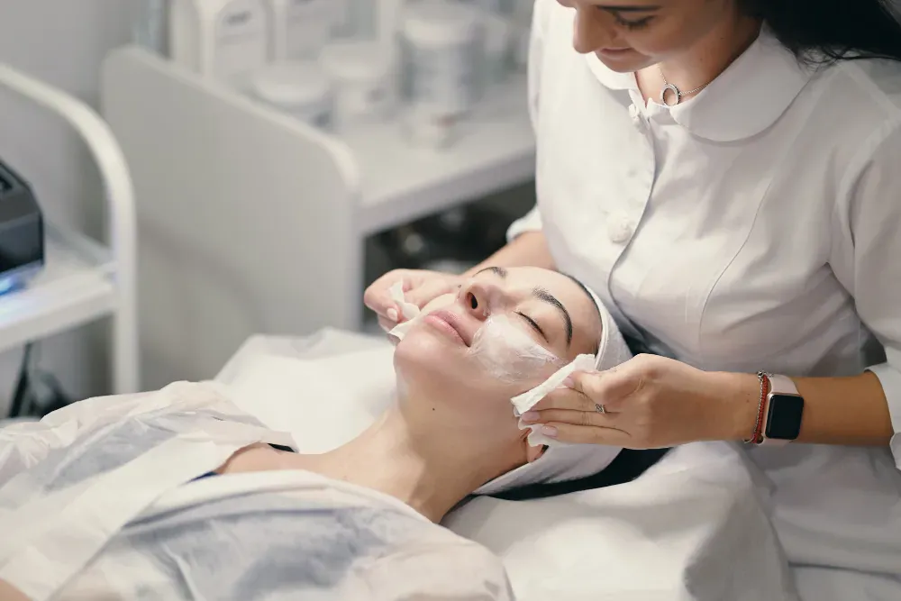 Aesthetician applying a chemical peel solution to a patient's face at PRP London Clinic